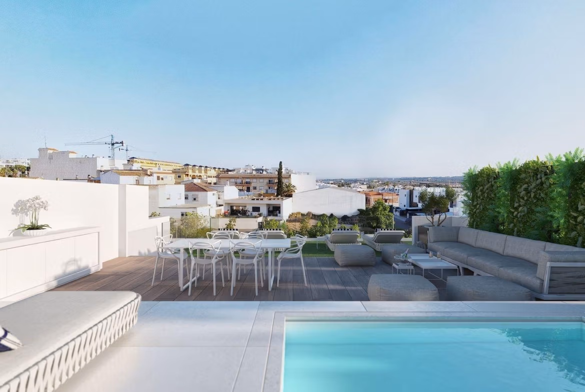 Ground floor apartment terrace in Benijofar with seating area, dining table, and communal pool overlooking town rooftops.