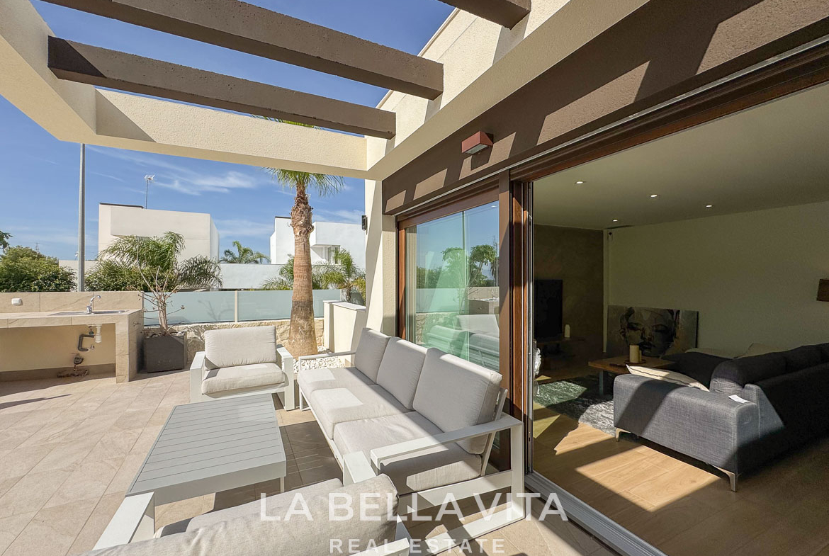 Sun-drenched terrace with elegant outdoor seating and sliding glass doors in a luxury single-storey villa, Benijófar, Costa Blanca