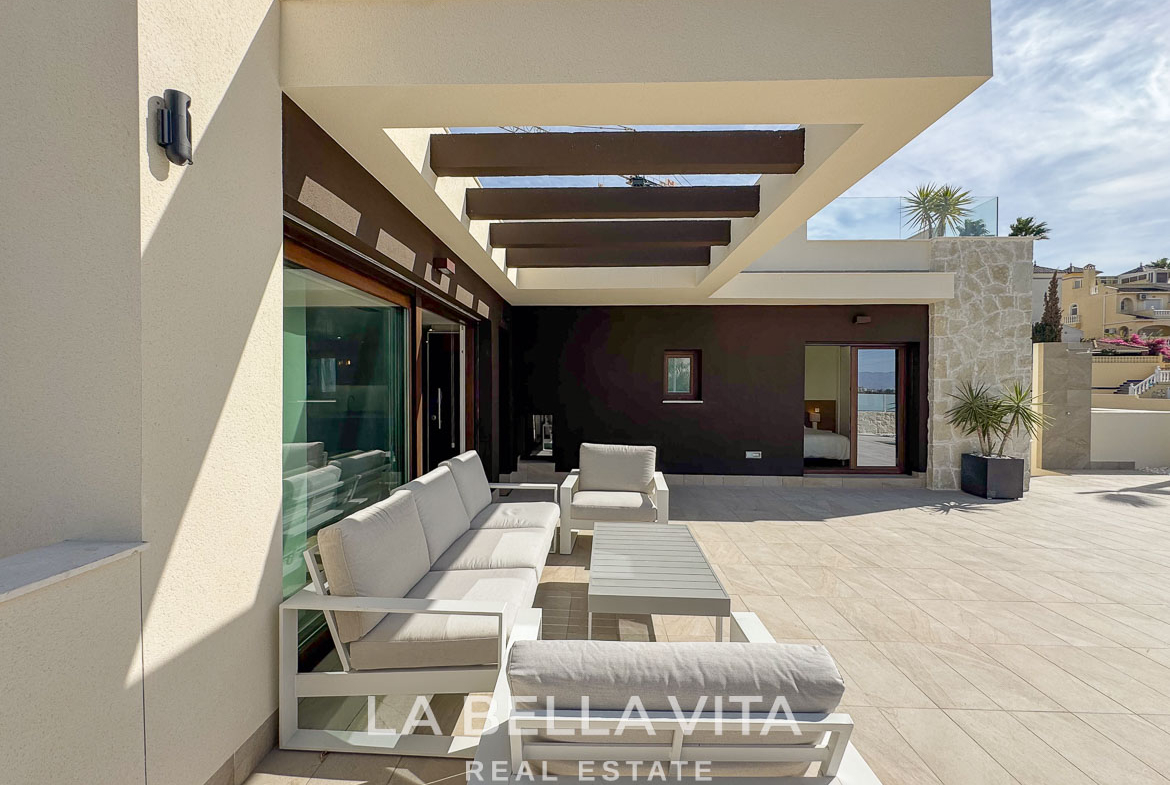 Spacious sun-drenched terrace with modern lounge seating of elegant single-storey villa in Benijófar, Costa Blanca.