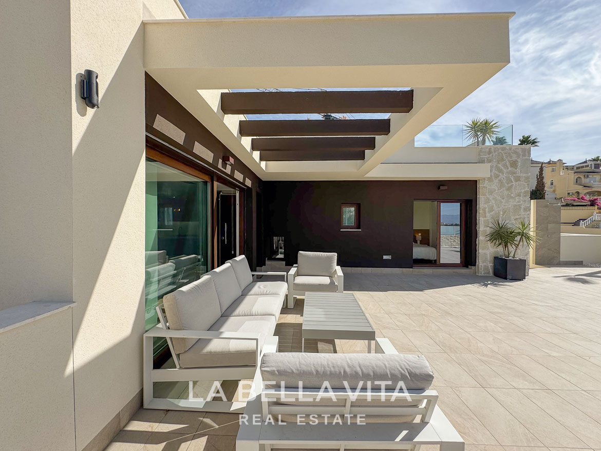 Spacious sun-drenched terrace with modern lounge seating of elegant single-storey villa in Benijófar, Costa Blanca.