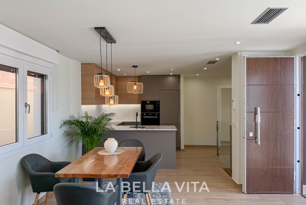 Bright, modern open-plan kitchen and dining area with stylish lighting in elegant single-storey villa, Benijófar, Costa Blanca.