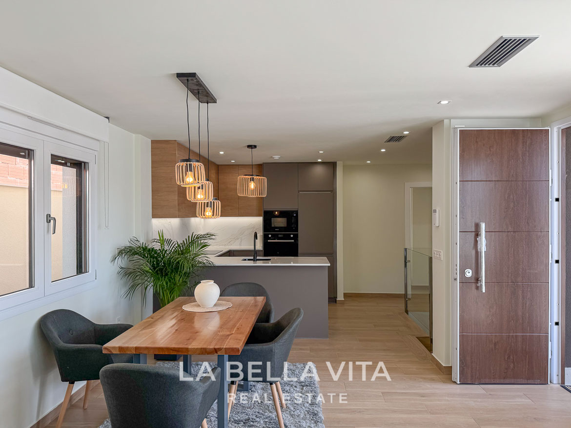 Bright, modern open-plan kitchen and dining area with stylish lighting in elegant single-storey villa, Benijófar, Costa Blanca.