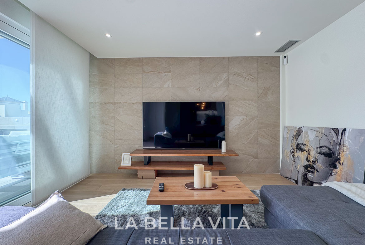 Bright, modern living room with sleek TV wall and cozy seating in elegant single-storey new build villa, Benijófar, Costa Blanca