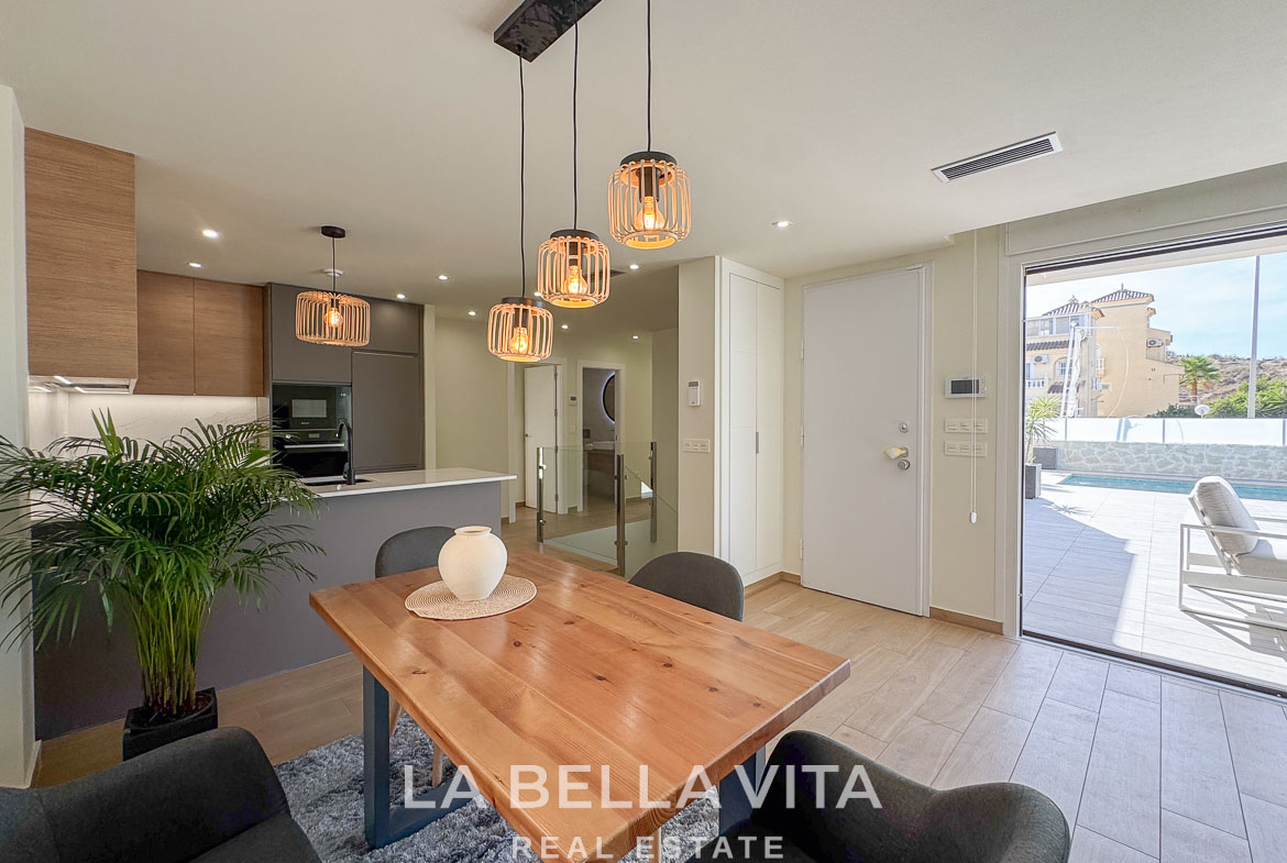 Bright open-plan dining and kitchen area with modern fixtures in an elegant single-storey villa in Benijófar, Costa Blanca