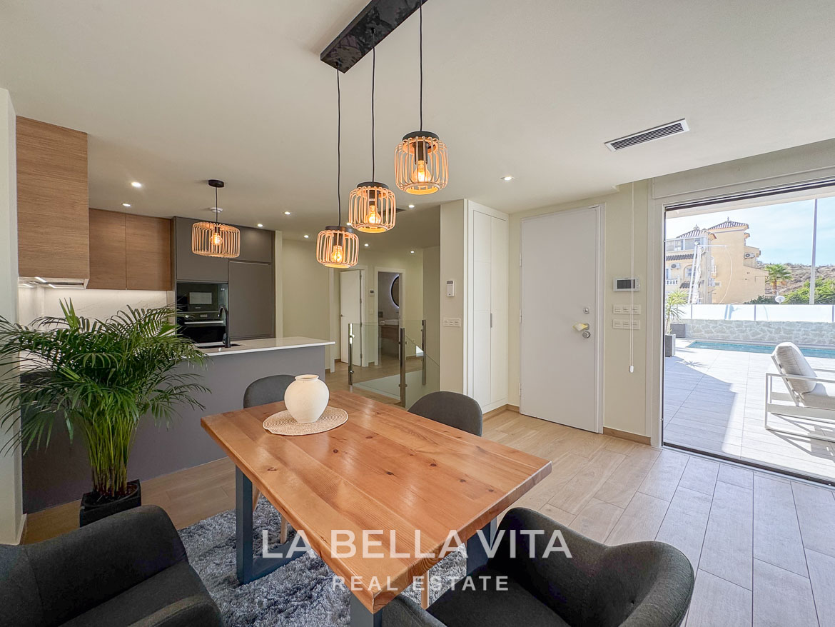Bright open-plan dining and kitchen area with modern fixtures in an elegant single-storey villa in Benijófar, Costa Blanca