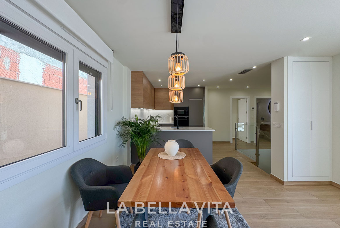 Bright, modern dining area with wooden table and pendant lighting in elegant single-storey villa in Benijófar, Costa Blanca