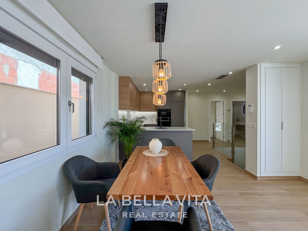 Bright, modern dining area with wooden table and pendant lighting in elegant single-storey villa in Benijófar, Costa Blanca