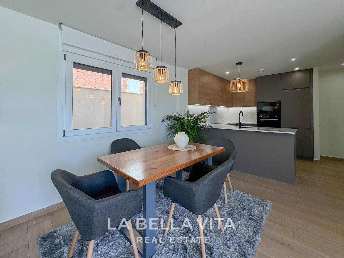 Bright, modern dining area with stylish lighting and sleek kitchen in elegant single-storey villa for sale in Benijófar, Costa Blanca