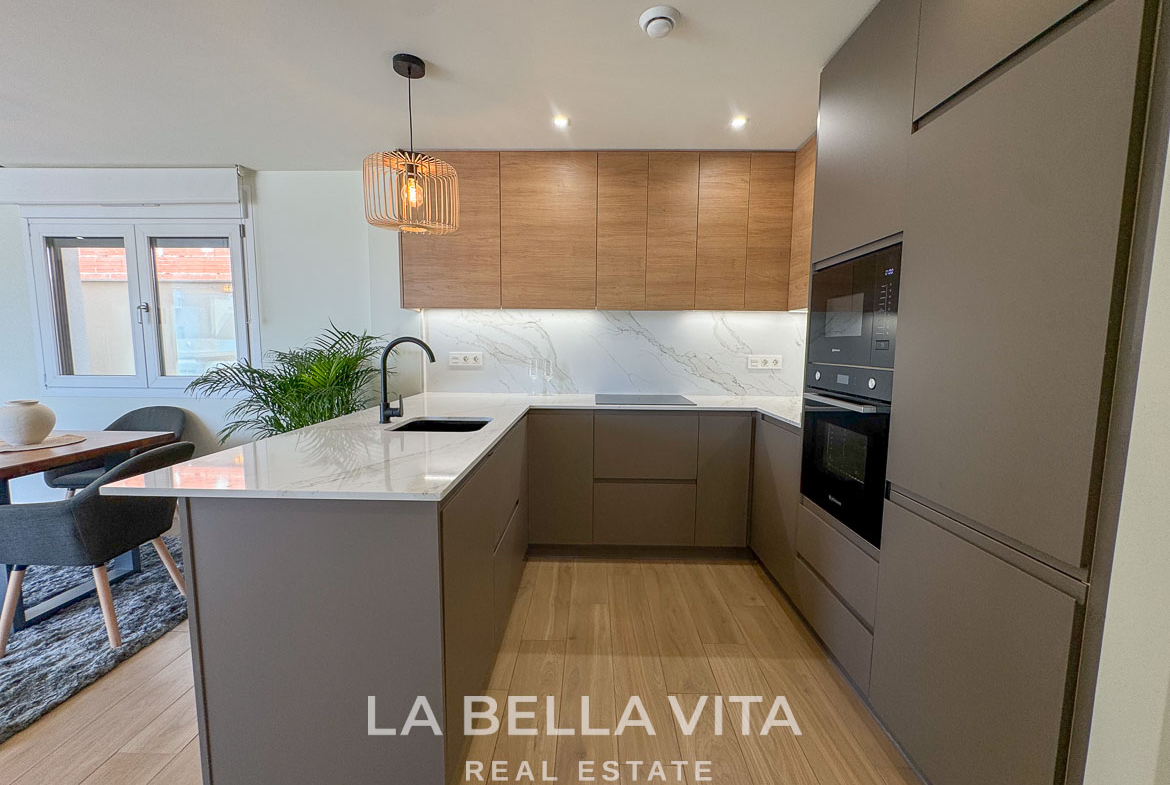 Modern, sleek kitchen with marble countertops and wood accents in elegant single-storey villa in Benijófar, Costa Blanca