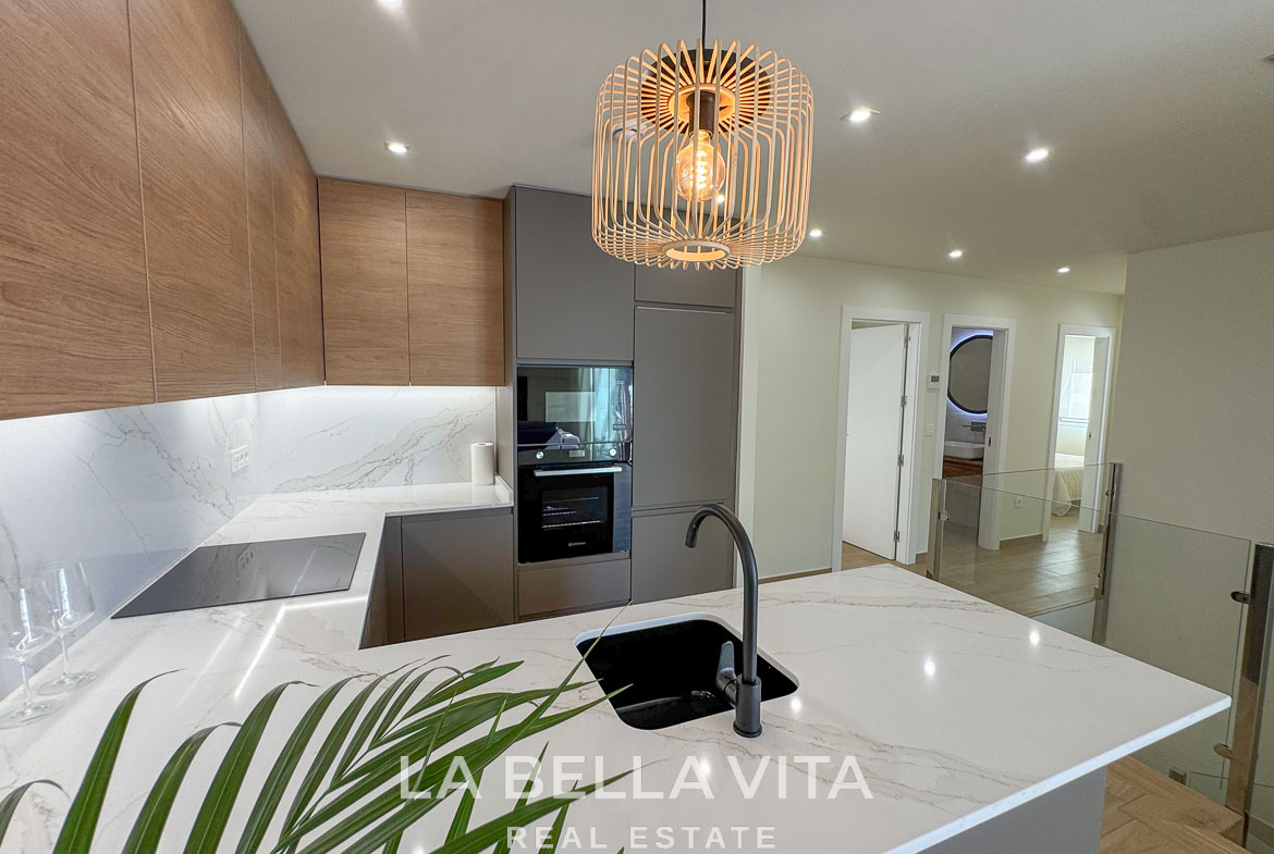 Modern open-plan kitchen with sleek cabinetry and marble countertops in elegant single-storey villa, Benijófar, Costa Blanca