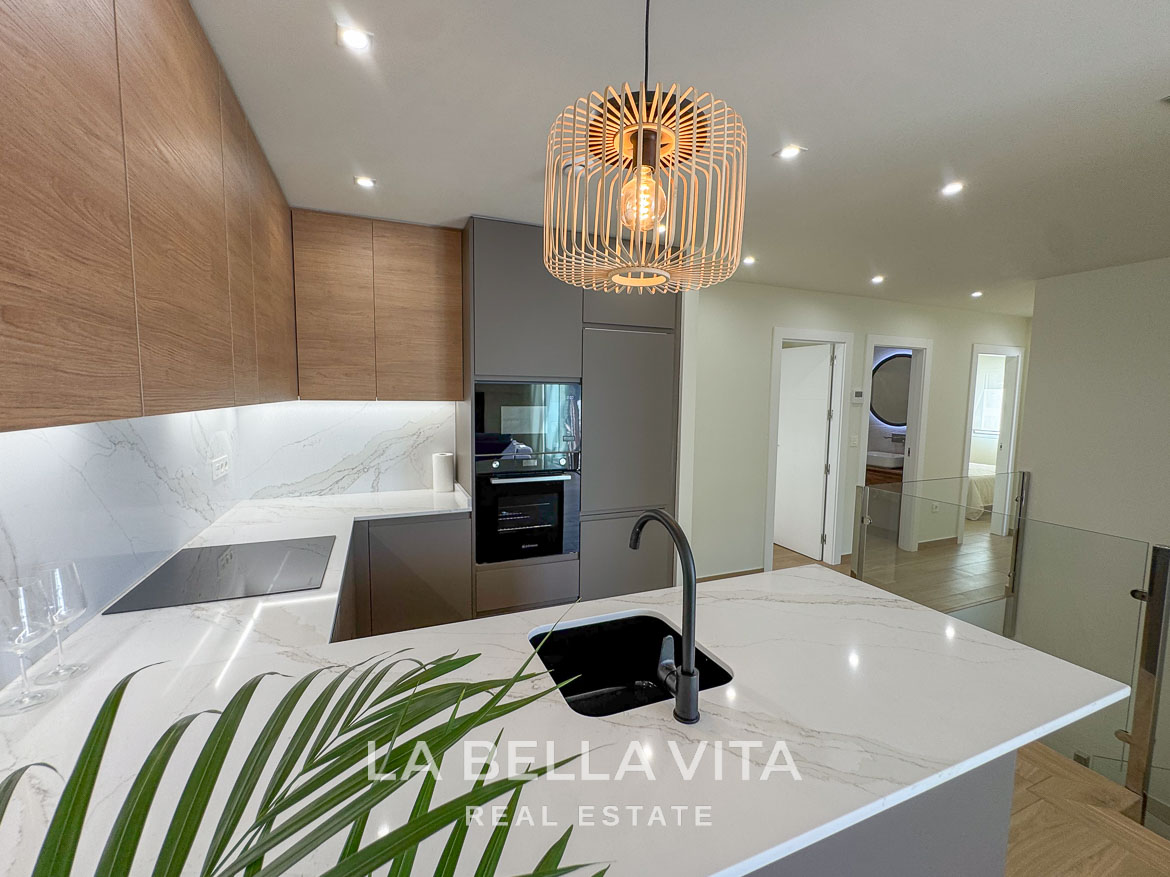 Modern open-plan kitchen with sleek cabinetry and marble countertops in elegant single-storey villa, Benijófar, Costa Blanca