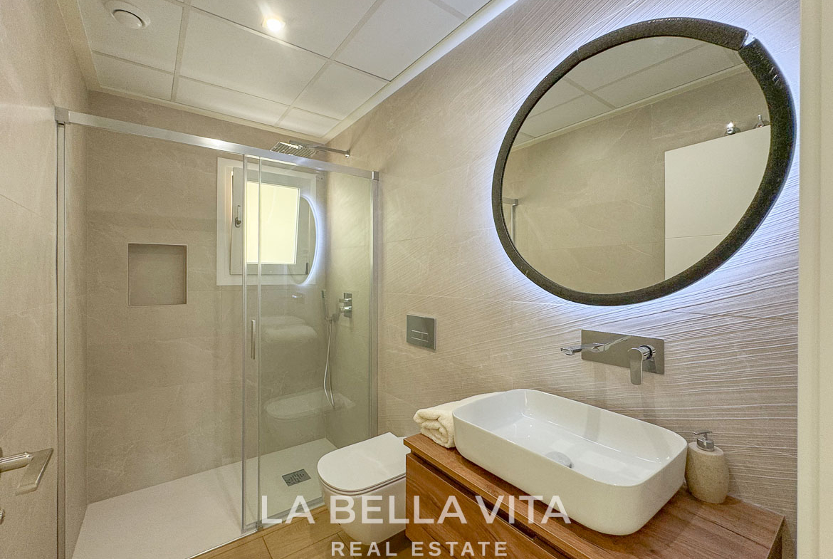 Modern, elegant bathroom with illuminated mirror and walk-in shower in a luxury single-storey villa in Benijófar, Costa Blanca.
