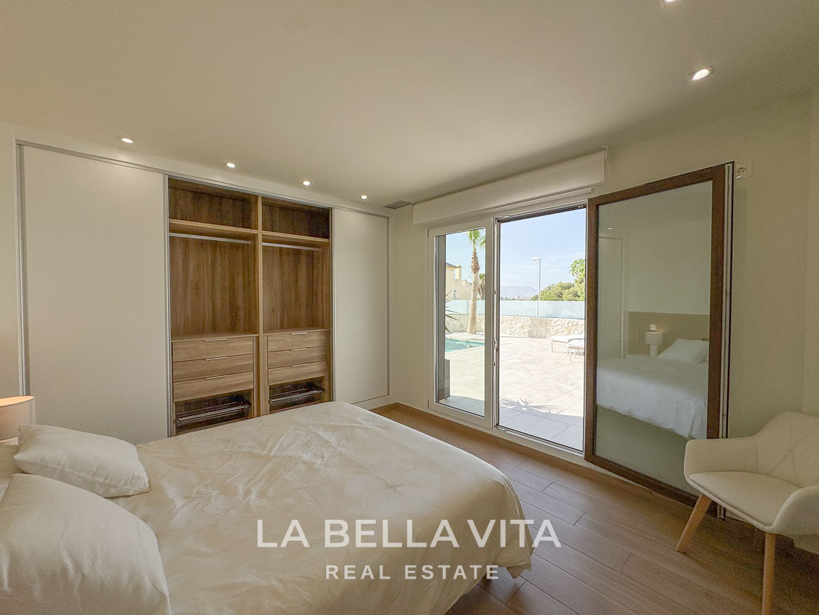 Bright and serene bedroom with modern built-in wardrobe and glass doors opening to sun-drenched terrace in Benijófar villa