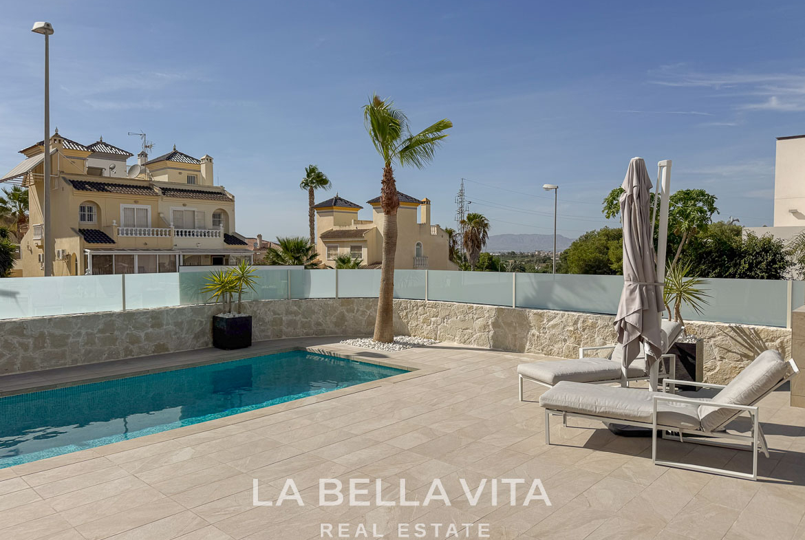 Sun-drenched private pool with sleek loungers and palm tree in elegant single-storey villa in Benijófar, Costa Blanca