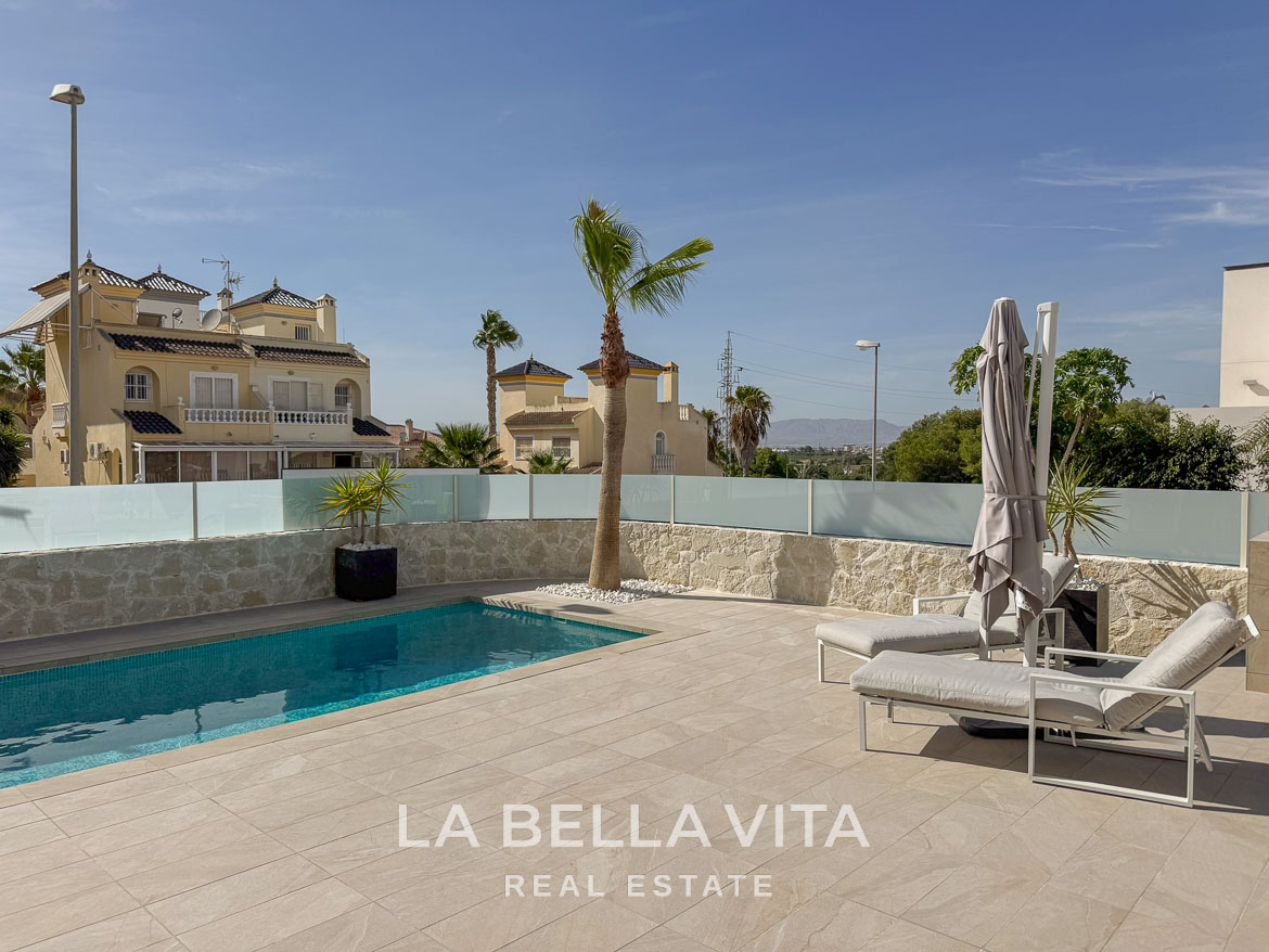 Sun-drenched private pool with sleek loungers and palm tree in elegant single-storey villa in Benijófar, Costa Blanca