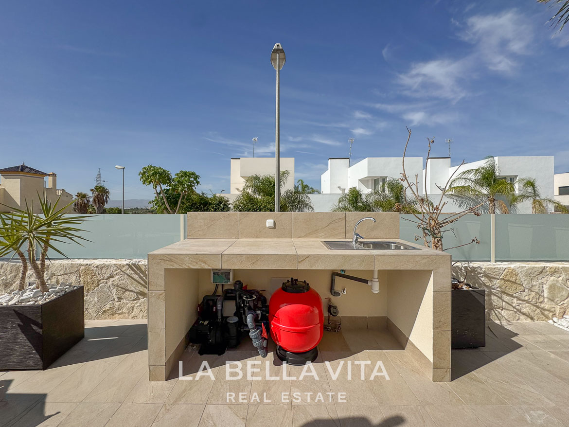 Modern outdoor kitchenette with sleek stone finish and landscaped terrace at elegant single-storey villa in Benijófar, Costa Blanca