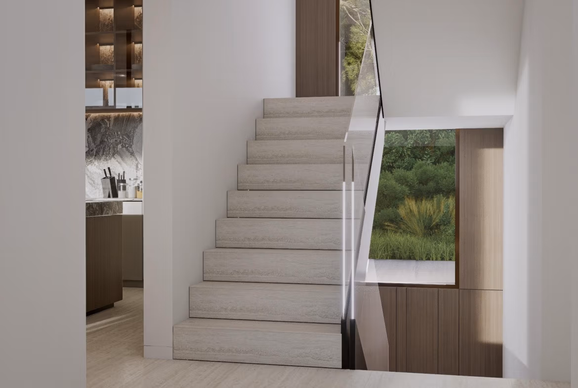 Interior stairway with glass railing in luxury villa at Las Colinas Golf Resort showing modern kitchen and greenery view.