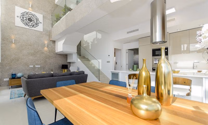 Open-plan living and kitchen area with dining table in modern design villa for sale in Ciudad Quesada.