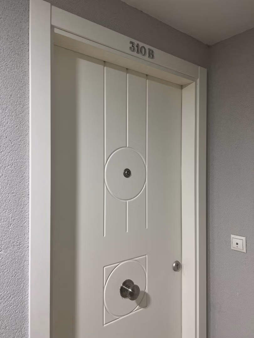 Elegant white entrance door of luxury 3 bedroom penthouse in Calpe with modern design details.