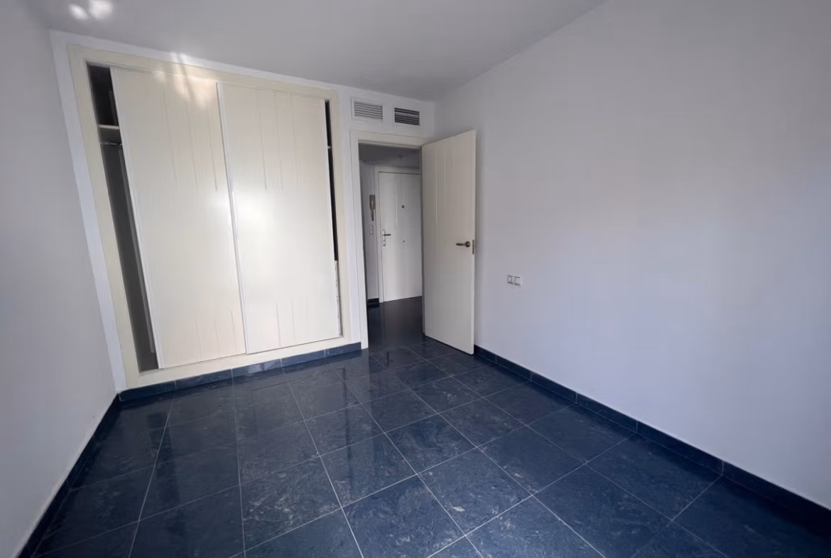 Bright, modern bedroom with sleek dark tile flooring and built-in closets in luxury 3 bedroom penthouse in Calpe