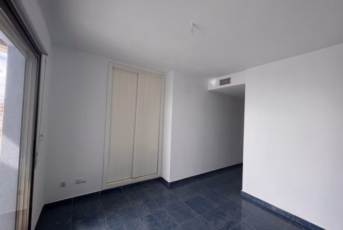 Bright, minimalist bedroom with sleek dark flooring in luxury 3-bedroom penthouse with sea views in Calpe
