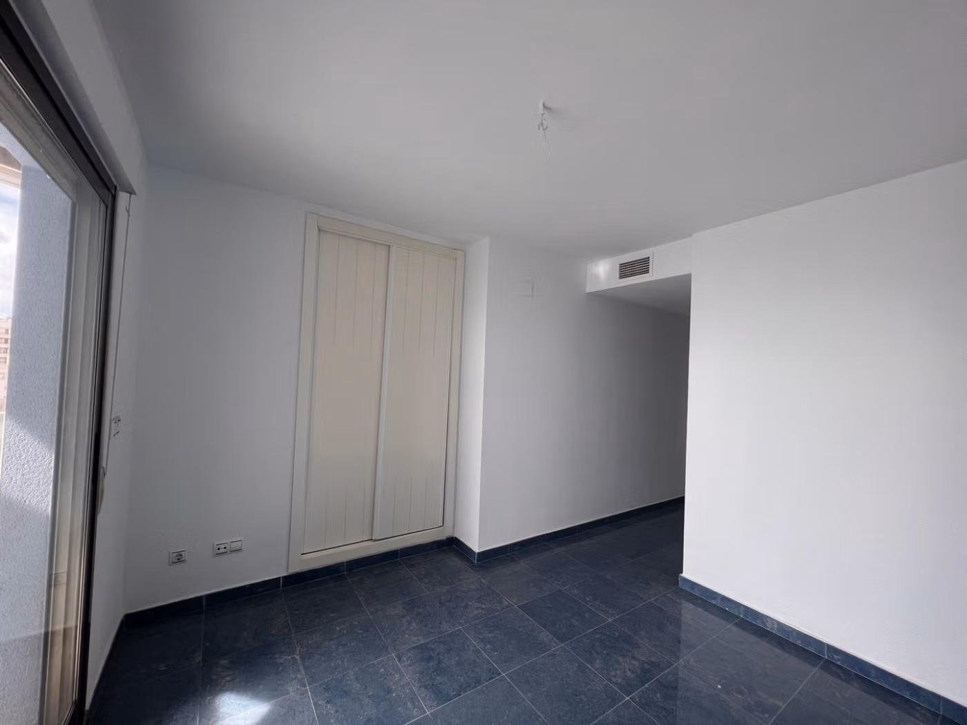 Bright, minimalist bedroom with sleek dark flooring in luxury 3-bedroom penthouse with sea views in Calpe