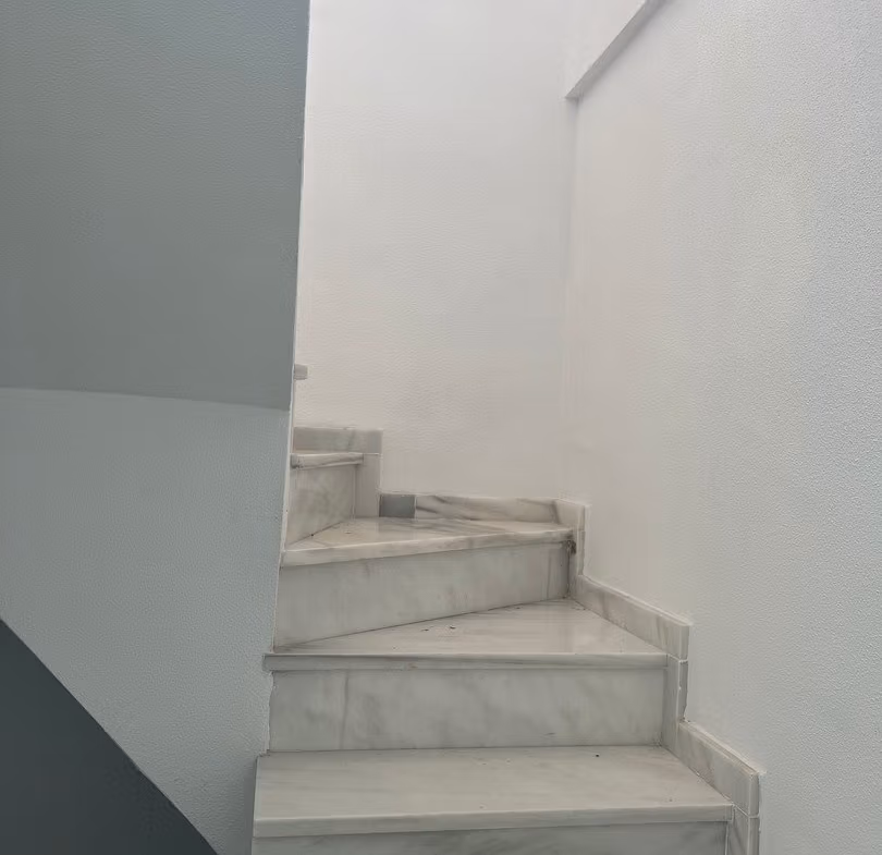 Elegant marble staircase in luxury 3 bedroom penthouse in Calpe, leading to the sun-drenched solarium with sea views.