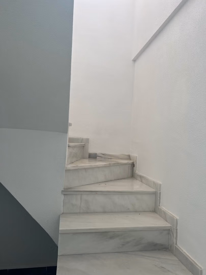 Elegant marble staircase in luxury 3 bedroom penthouse in Calpe, leading to the sun-drenched solarium with sea views.