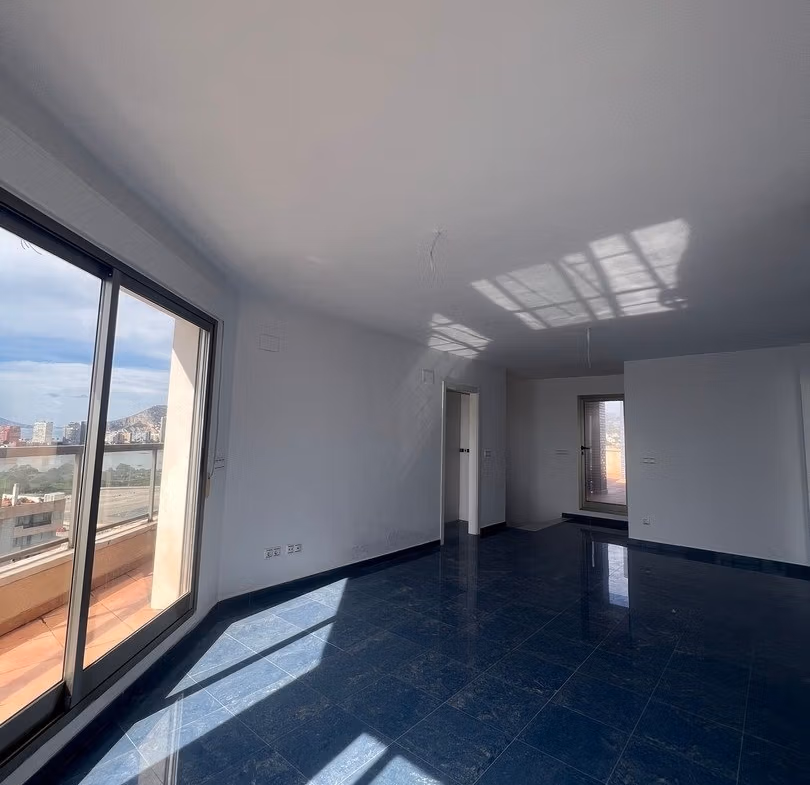 Bright, spacious living room with large glass doors and panoramic views in luxury 3-bedroom penthouse in Calpe.