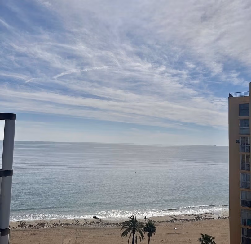 Panoramic sea view from the sun-drenched luxury 3 bedroom penthouse solarium in Calpe with pristine beachfront below.