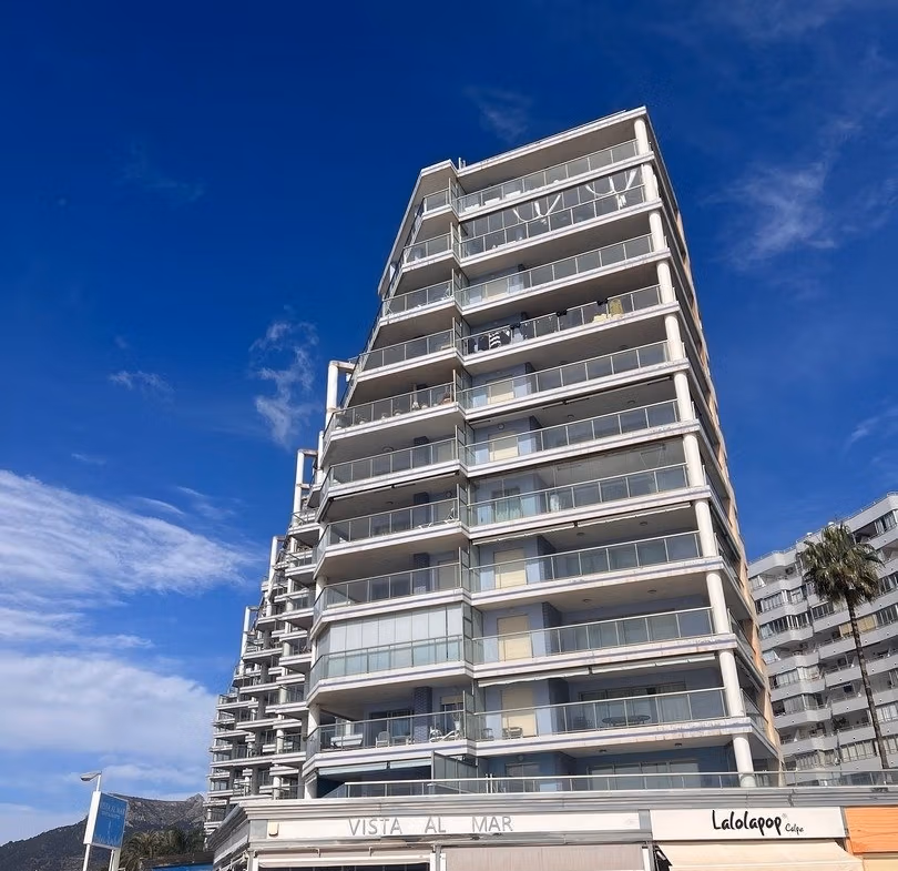 Modern luxury 3 bedroom penthouse in Calpe with panoramic sea views and spacious sunlit balconies under a bright blue sky.