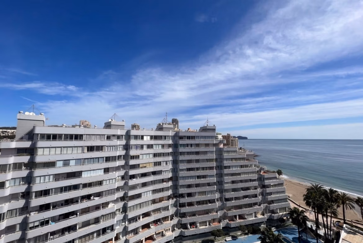 Modern luxury 3-bedroom penthouse in Calpe with expansive sun-drenched terraces overlooking the serene sea and beachfront pool.
