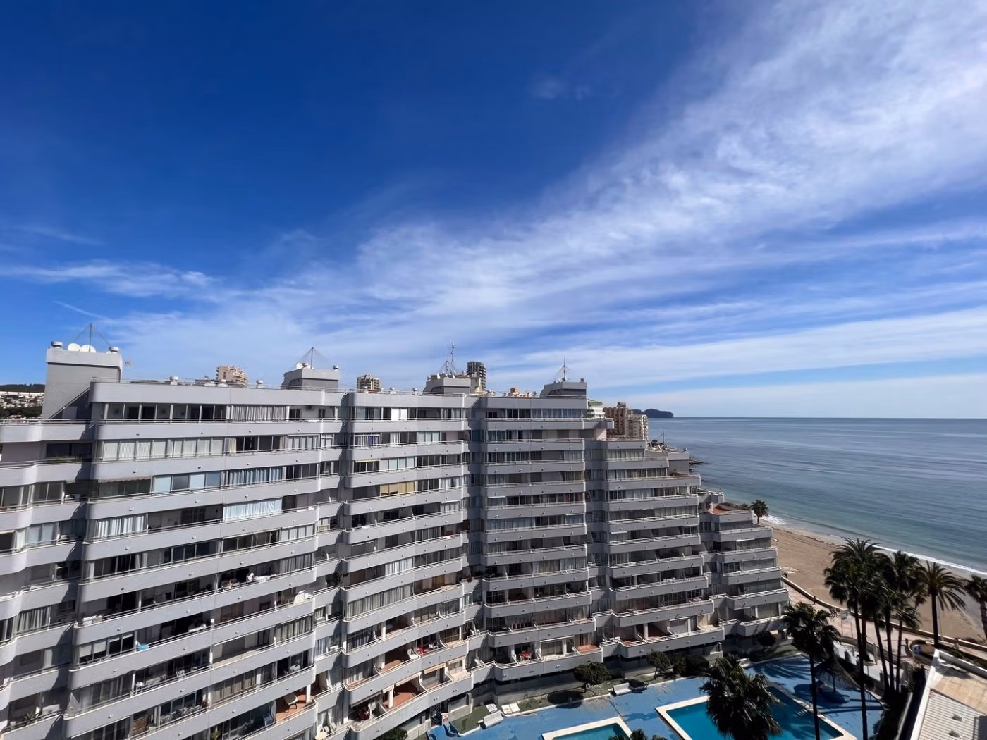 Modern luxury 3-bedroom penthouse in Calpe with expansive sun-drenched terraces overlooking the serene sea and beachfront pool.