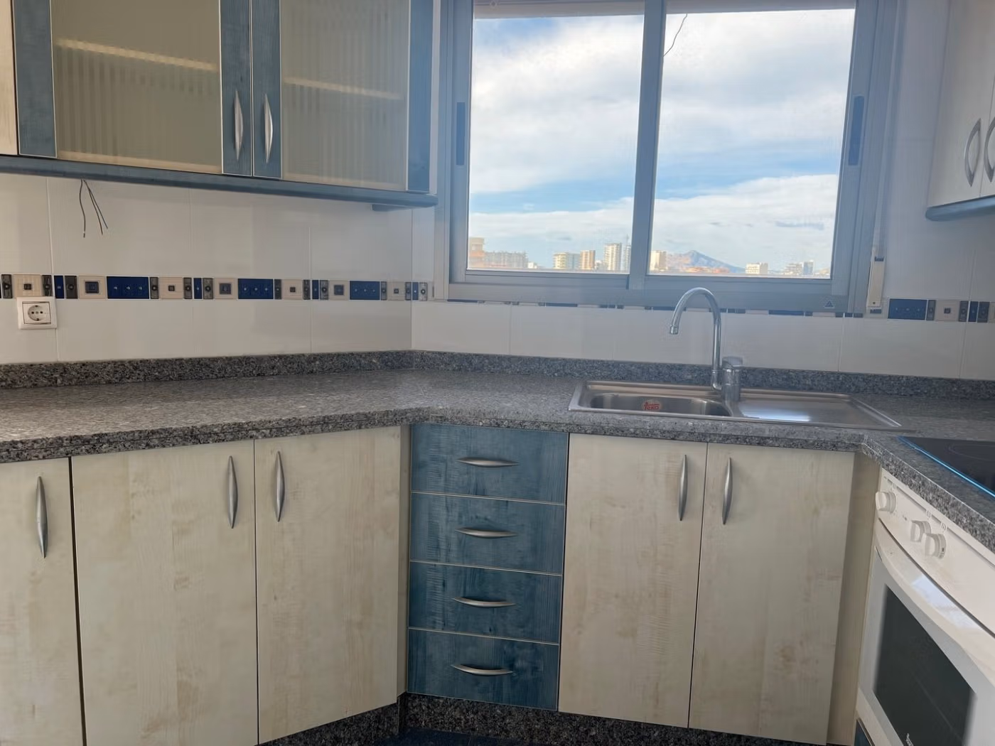Bright, modern kitchen with granite countertops and city views in luxury 3-bedroom penthouse for sale in Calpe.