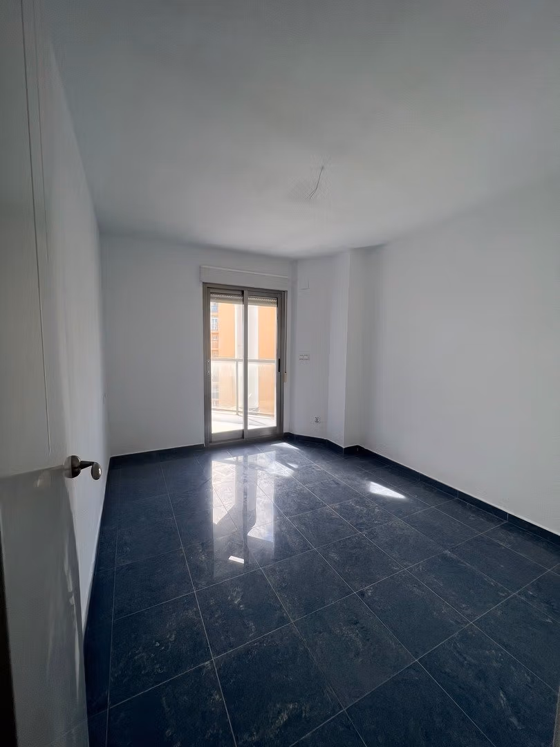 Bright spacious bedroom with dark marble flooring and balcony access in luxury 3-bedroom penthouse for sale in Calpe.