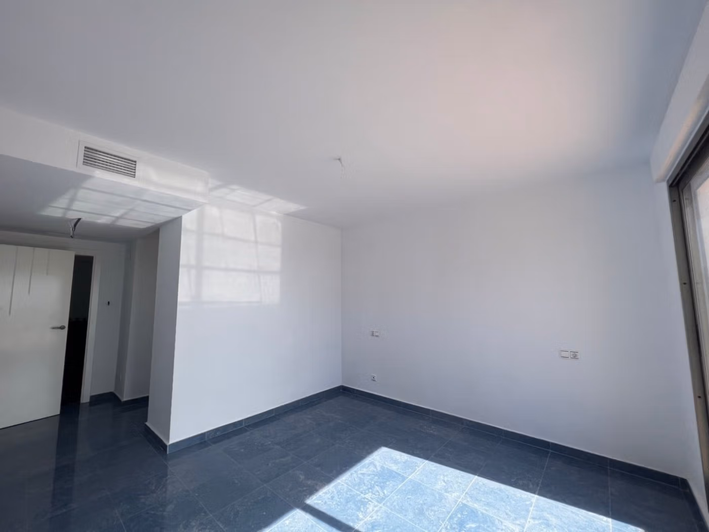 Bright, spacious bedroom with modern finishes and sleek flooring in luxury 3-bedroom penthouse in Calpe.