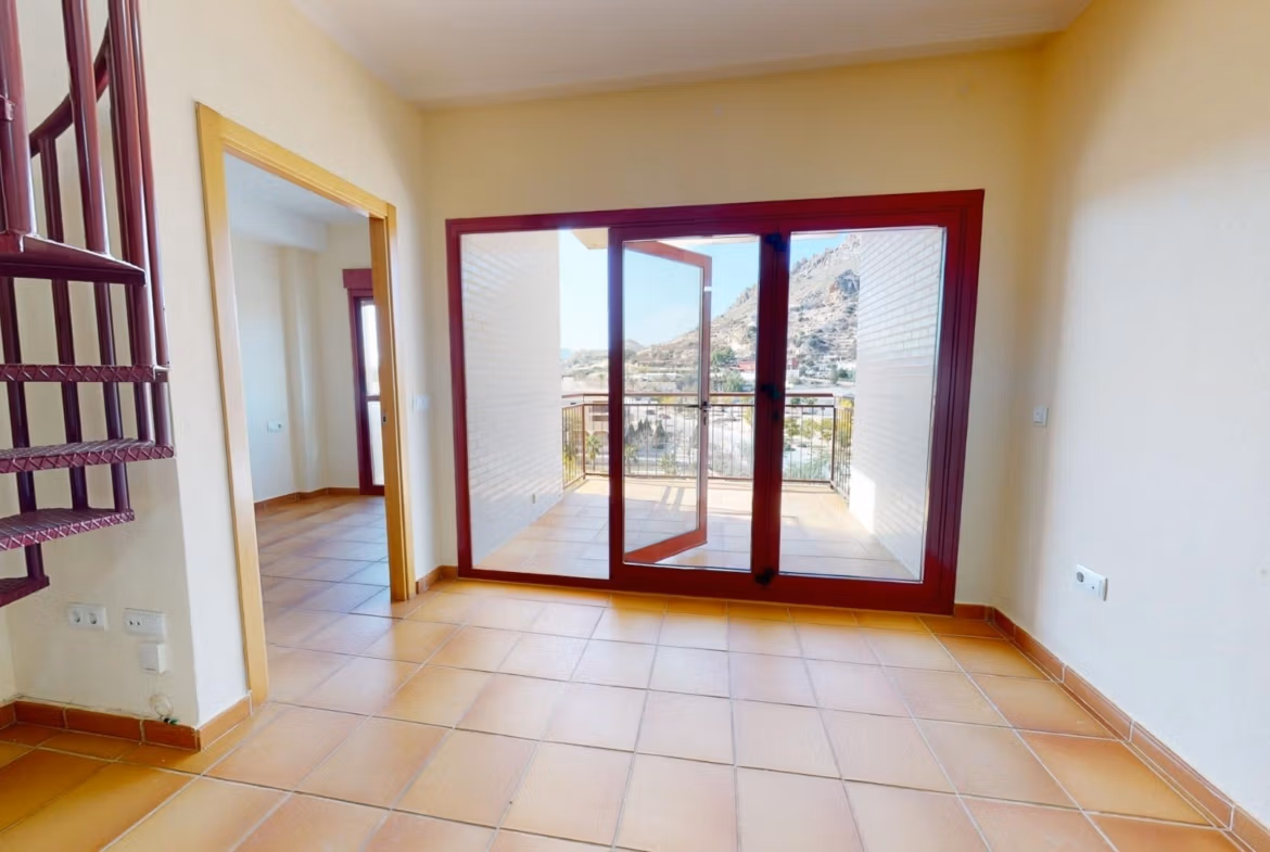 Bright open-plan living area with tiled floors and spiral staircase leading to solarium in 2-bedroom penthouse near Archena, Murcia