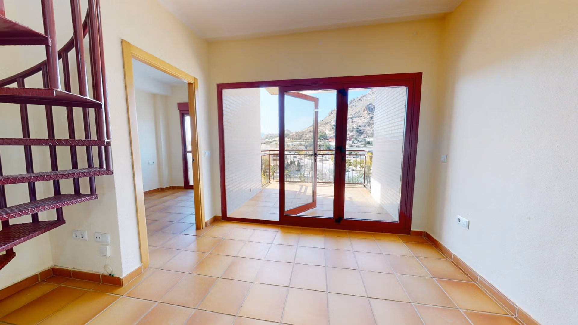Bright open-plan living area with tiled floors and spiral staircase leading to solarium in 2-bedroom penthouse near Archena, Murcia