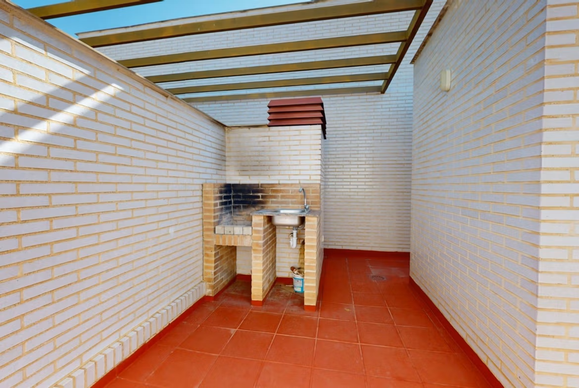 Sunlit private solarium with built-in barbecue and terracotta flooring in spacious 2-bedroom penthouse near Archena, Murcia.