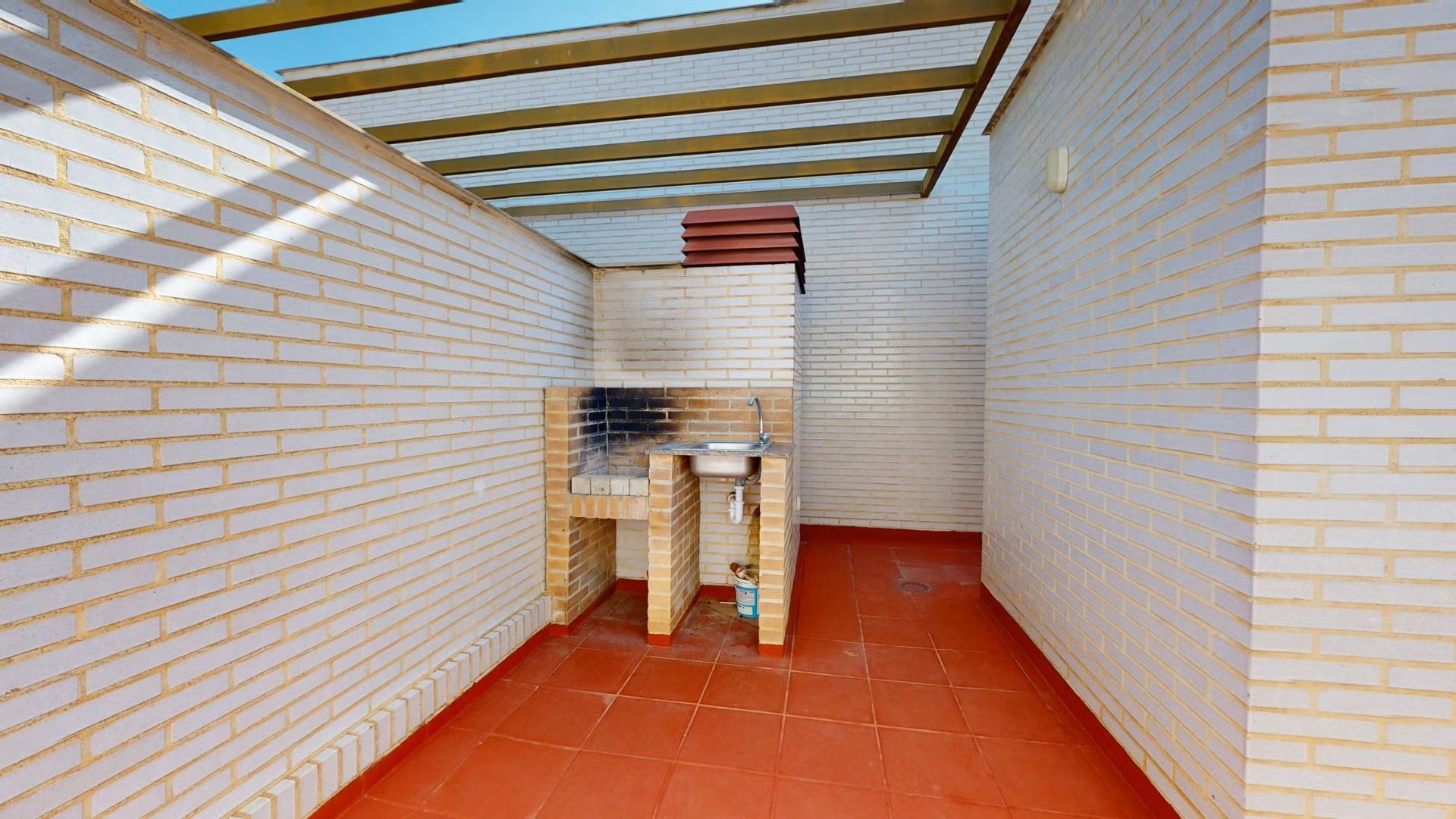 Sunlit private solarium with built-in barbecue and terracotta flooring in spacious 2-bedroom penthouse near Archena, Murcia.