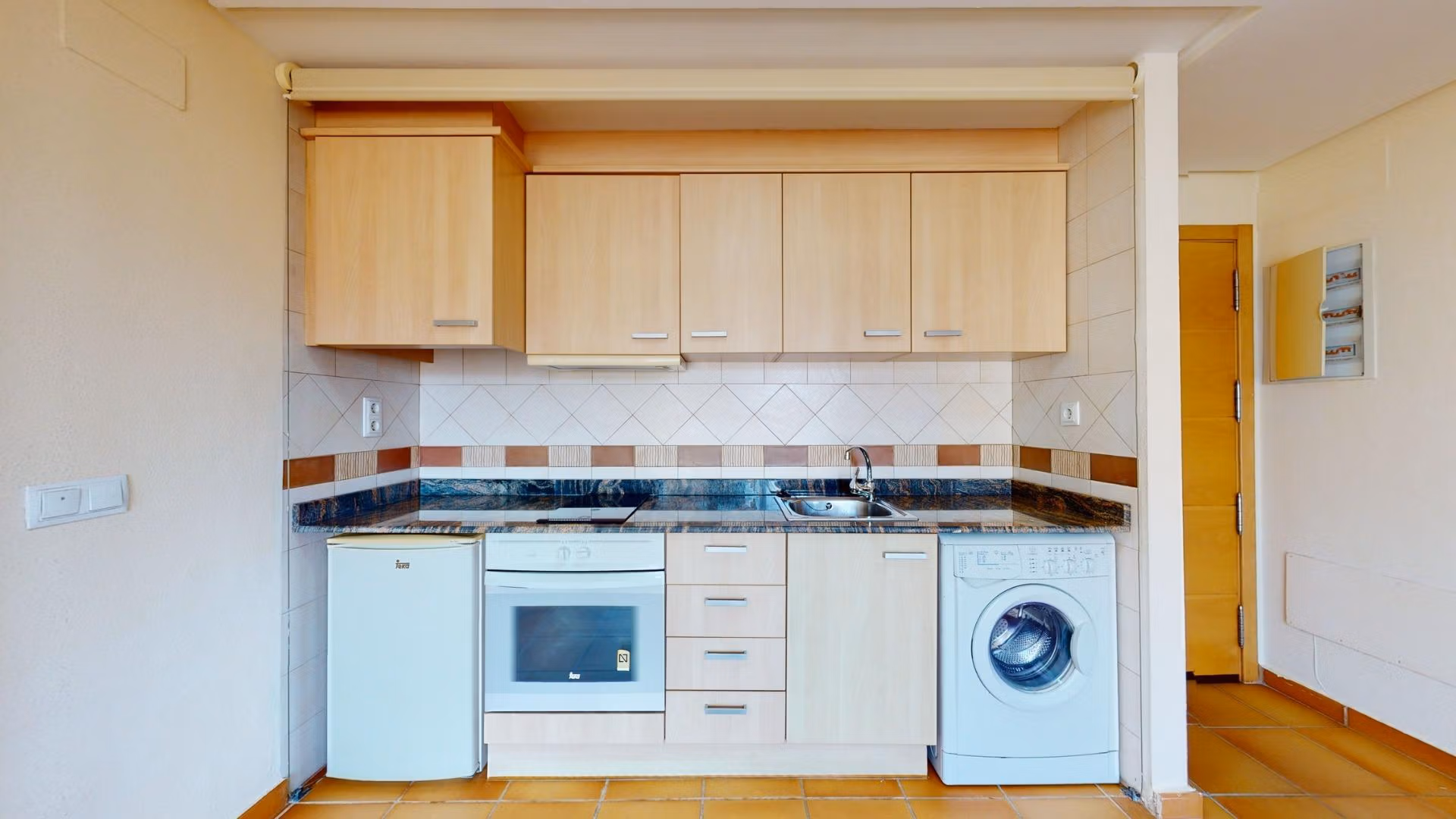 Bright, modern kitchen in a 2-bedroom penthouse near Archena, Murcia, featuring sleek cabinetry and compact appliances.