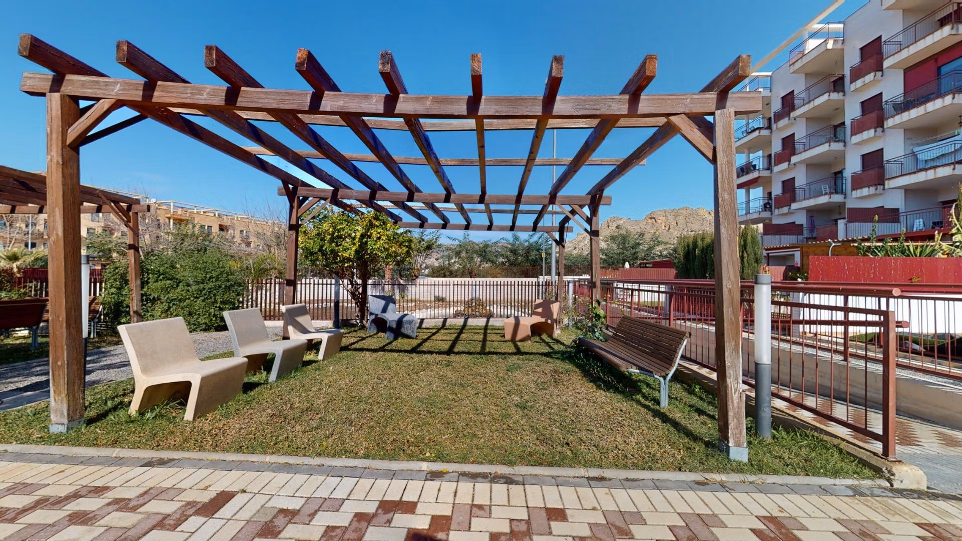 Sun-drenched landscaped terrace with wooden pergola and seating area at luxury 2-bedroom penthouse near Archena, Murcia