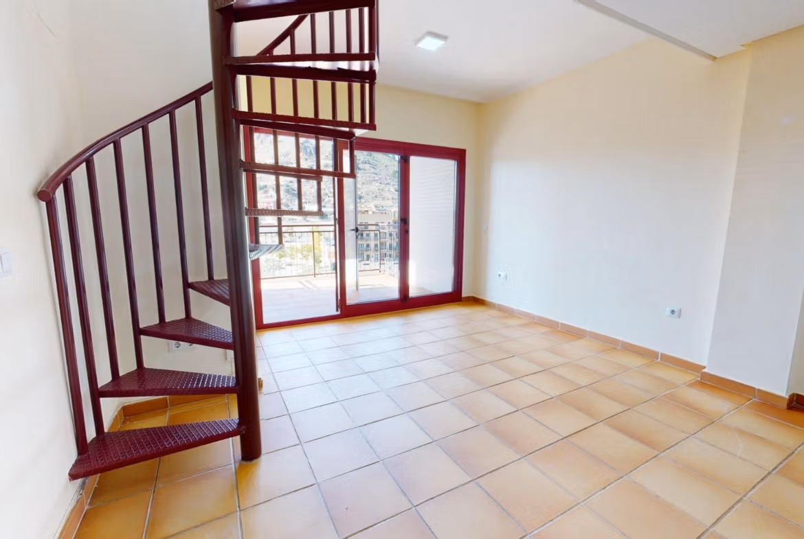 Bright spacious living area with terracotta floors and spiral staircase leading to solarium in a 2-bedroom penthouse near Archena, Murcia