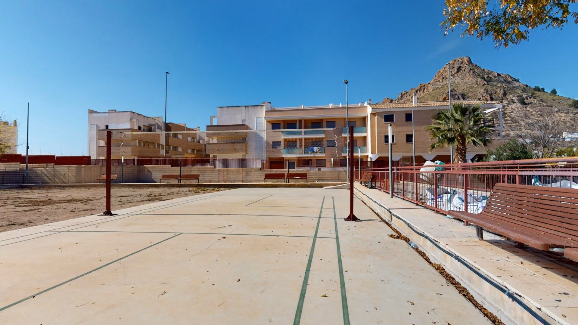 Spacious outdoor sports court with seating and mountain backdrop at luxury 2-bedroom penthouse near Archena, Murcia.