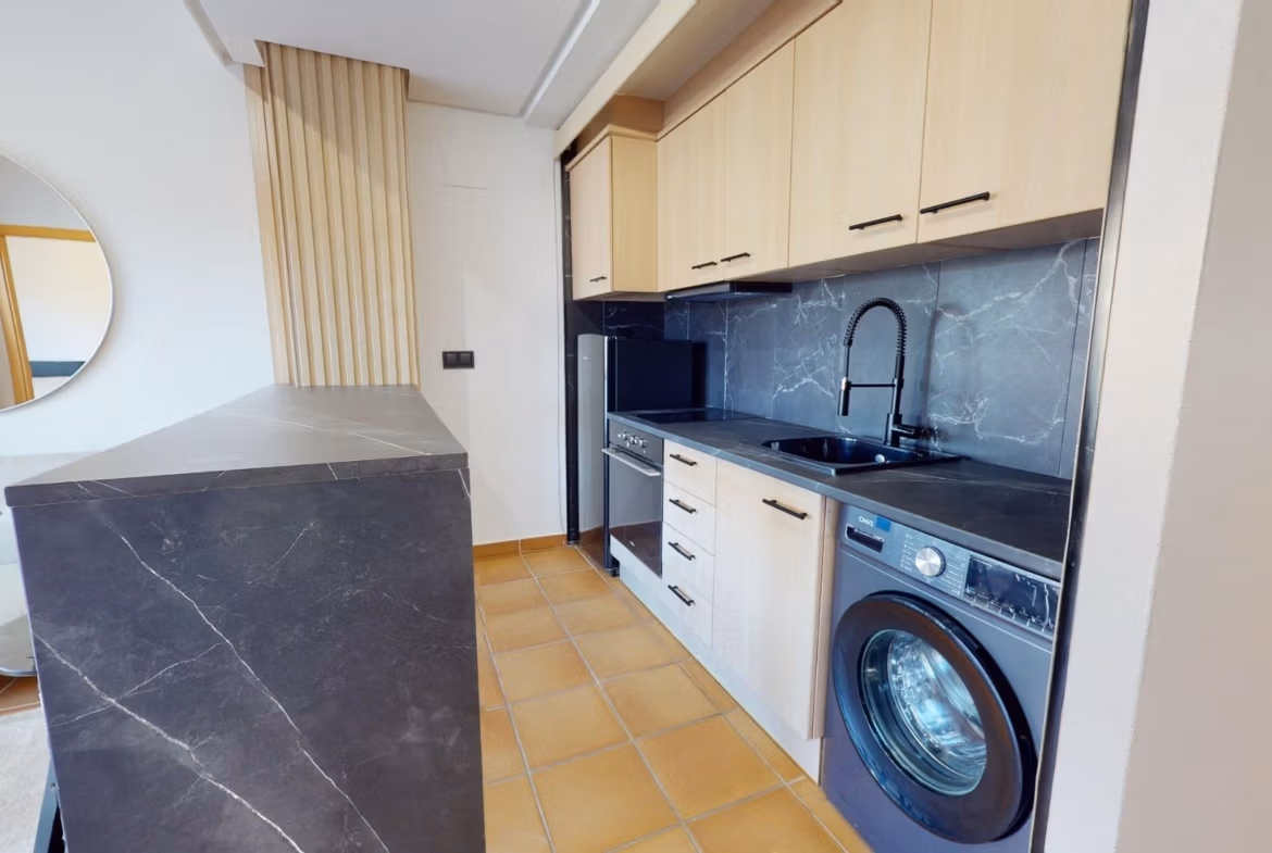 Bright, modern kitchen with sleek black marble counters in a charming key-ready 1 bedroom apartment in Villanueva del Rio Segura.