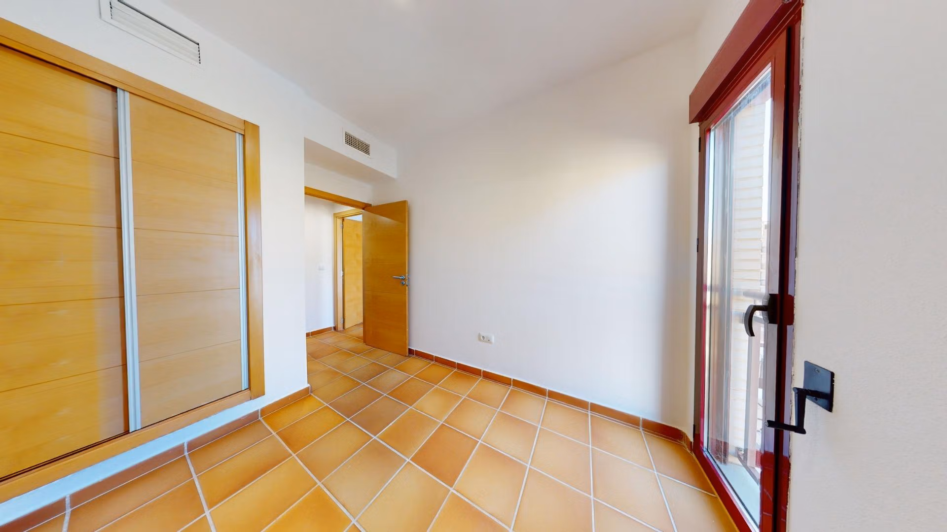 Bright spacious bedroom with terracotta floors and built-in wardrobe in luxury 2-bedroom penthouse near Archena, Murcia.