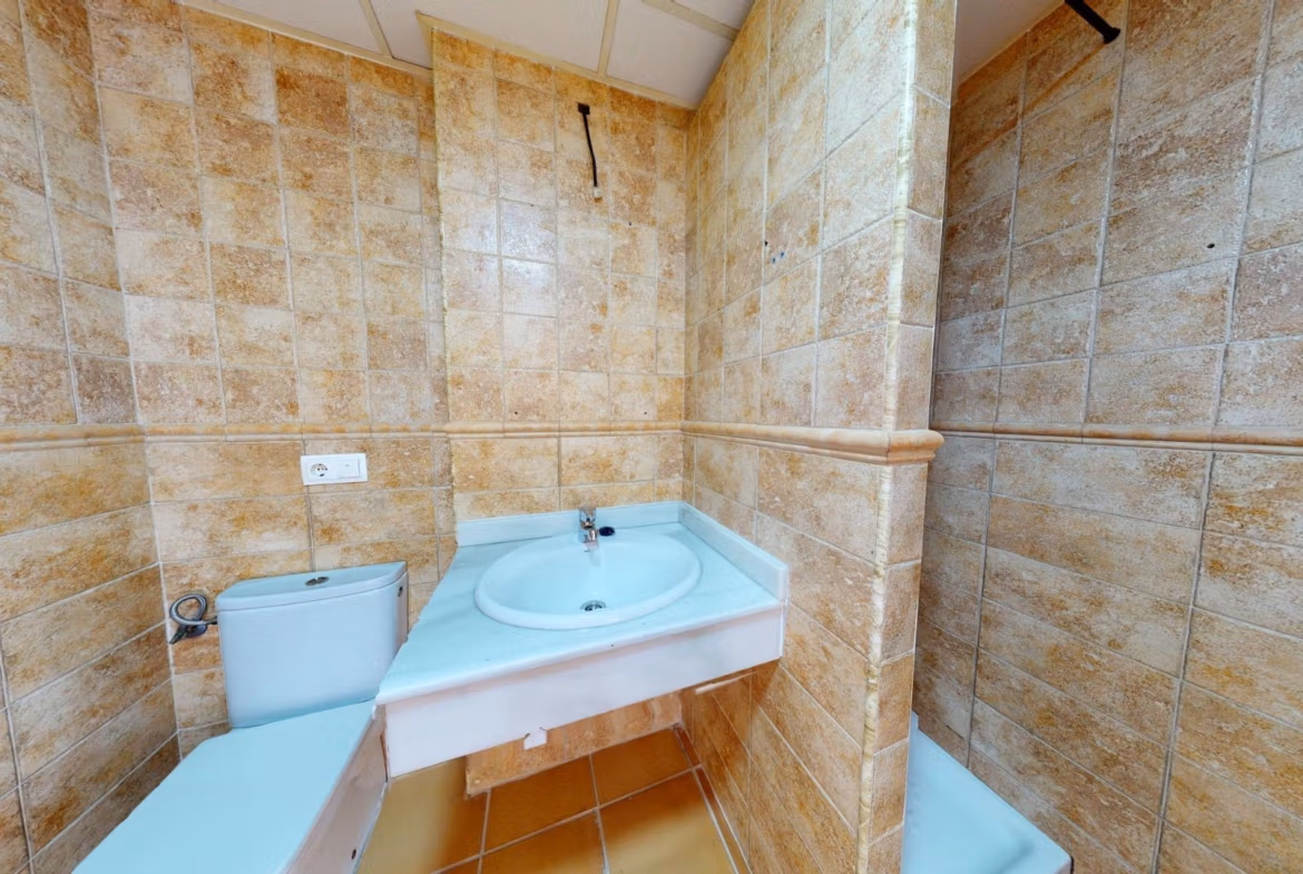Bright and modern bathroom with elegant tiled walls in a 2-bedroom penthouse near Archena, Murcia.