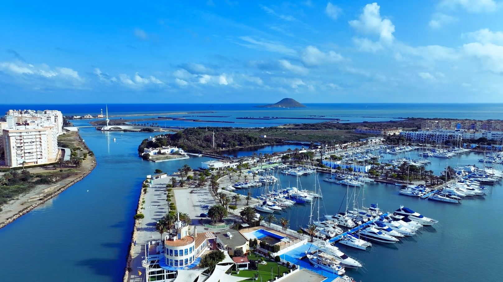 BEAUTIFUL-TOWNHOUSES-IN-LA-MANGA-19 Panoramic aerial view of sunny marina with luxury yachts and bright new build 2-bedroom townhouse for sale in La Manga del Mar Menor.