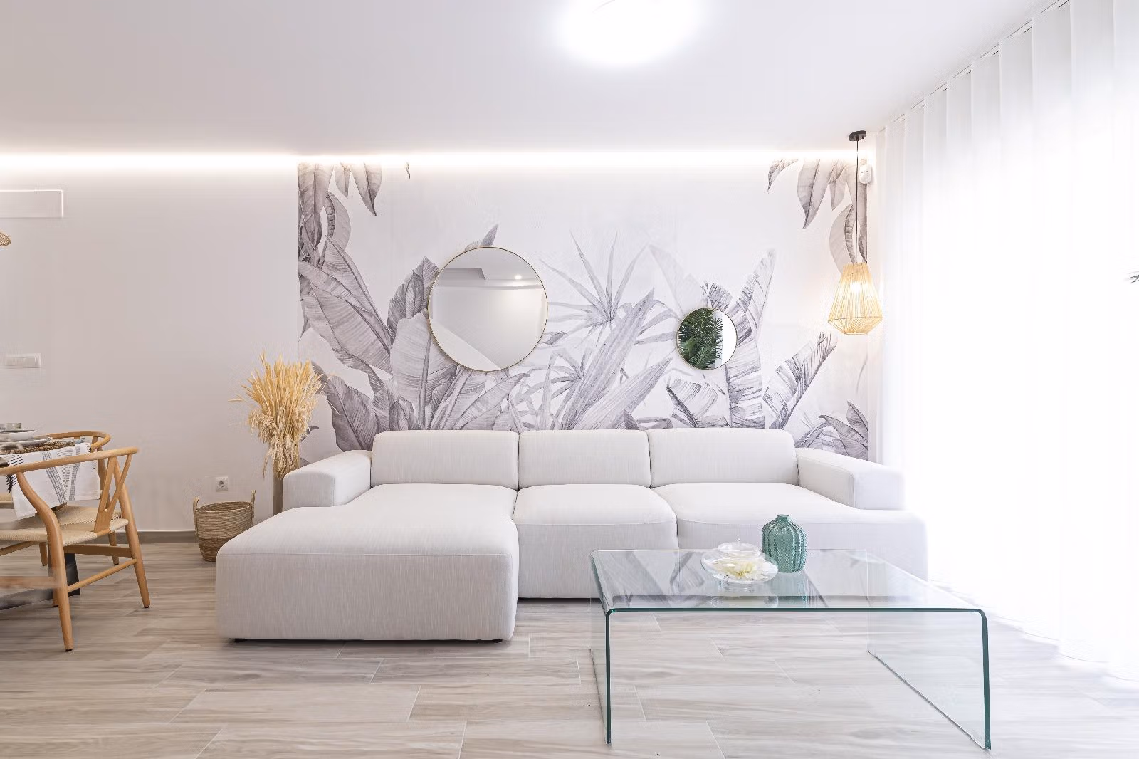BEAUTIFUL-TOWNHOUSES-IN-LA-MANGA-7 Bright, modern living room with stylish sofa and tropical mural in a 2-bedroom townhouse in La Manga del Mar Menor.