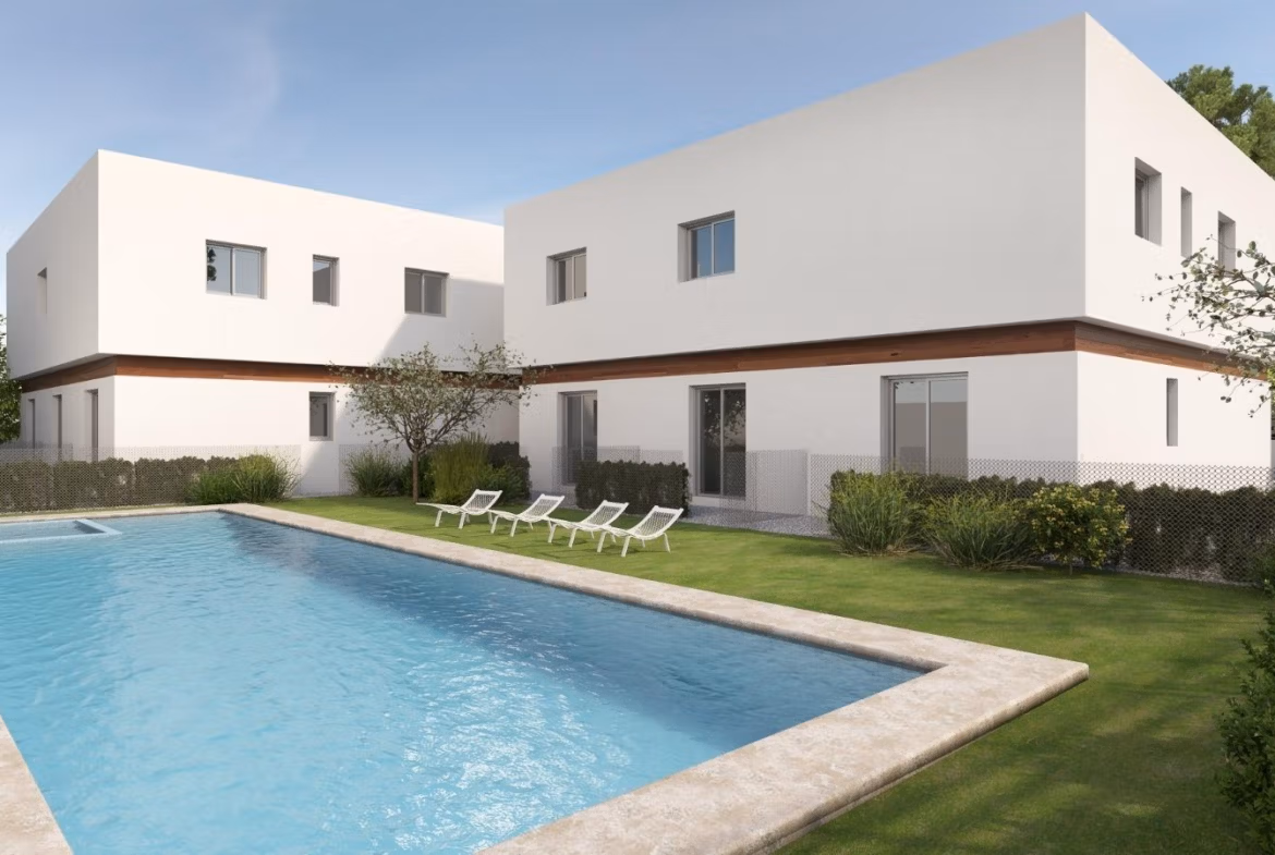 Modern 2-bedroom townhouse in Orihuela Costa with sleek white exterior, lush landscaping, and a sparkling communal pool under clear skies.